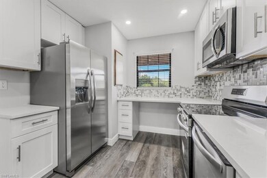 Kitchen featuring appliances with stainless steel finishes, wood finished floors, white cabinets, light countertops, and recessed lighting
