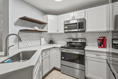 Kitchen with white cabinets, stainless steel appli