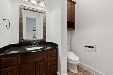 Half bath with toilet, vanity, tile patterned flo