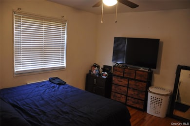 Bedroom with dark wood-type flooring and ceiling fan