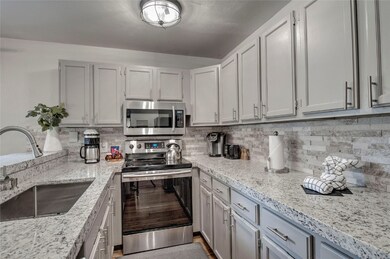 Beautifully remodeled kitchen including stone back