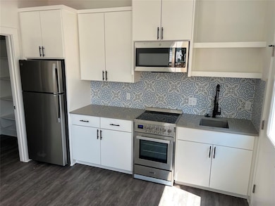 Kitchen with stainless steel appliances, dark woo