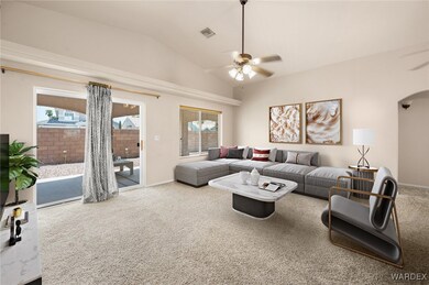 Living room with ceiling fan, vaulted ceiling, and