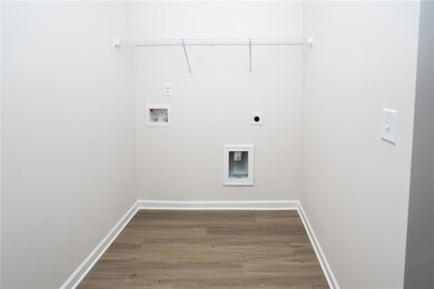 Washroom with electric dryer hookup, wood finished floors, washer hookup, and baseboards