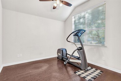 Workout room with ceiling fan, vaulted ceiling, an