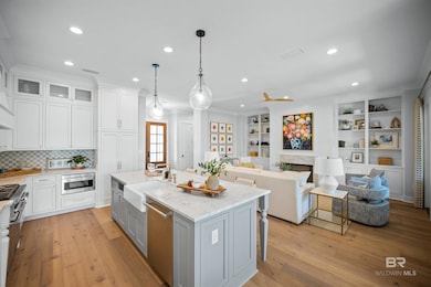 Kitchen with open floor plan, gray cabinets, white cabinetry, decorative light fixtures, and recessed lighting
