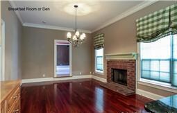 The eating area immediately next to the kitchen is a happy, family space with a fireplace and large windows.