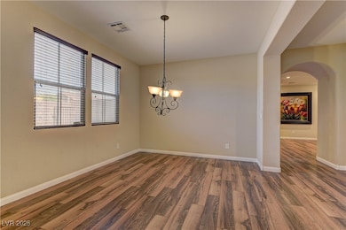 Empty room featuring arched walkways, wood finishe