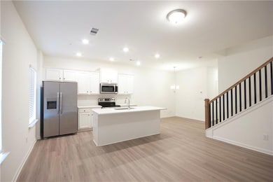 Kitchen featuring white cabinetry, sink, light woo