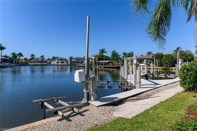 Dock featuring boat lift, a water view, and a residential view