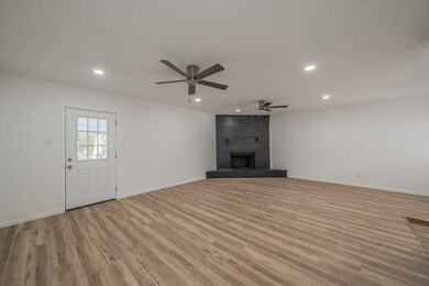Unfurnished living room with ceiling fan, recessed lighting, light wood finished floors, and a brick fireplace