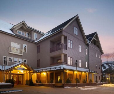 Back of property at dusk featuring a balcony