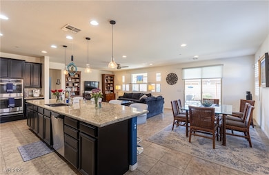 Kitchen with light stone counters, visible vents,