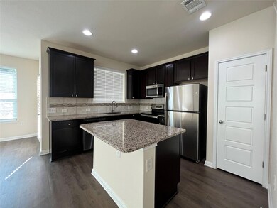 Kitchen with stainless steel appliances, dark woo