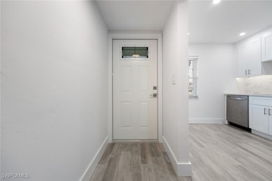 Doorway featuring light wood finished floors, base