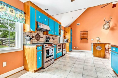 Kitchen with backsplash, lofted ceiling, stainless
