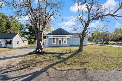 View of front of home featuring concrete driveway, a front yard, and covered porch