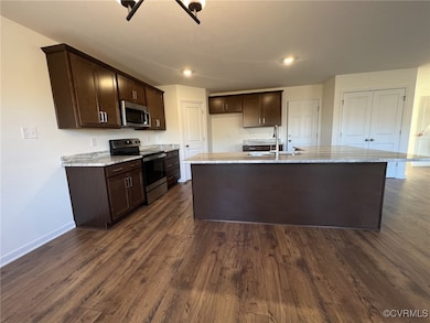 Kitchen featuring stainless steel appliances, dark