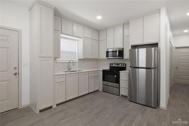 Kitchen with appliances with stainless steel finishes, light wood-type flooring, white cabinetry, and recessed lighting
