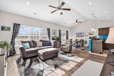 Living room featuring ceiling fan, lofted ceiling,