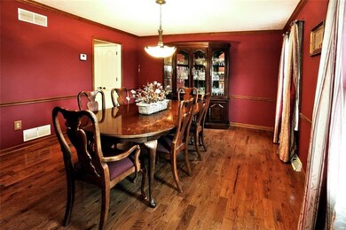 Large dining room with hardwood floors, crown mold