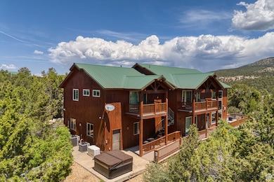 Back of property with a patio area, a deck, stairway, and a metal roof