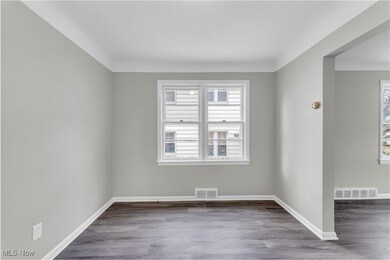 Spare room with a wealth of natural light, visible vents, and wood finished floors