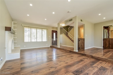 Unfurnished living room featuring wood finished fl