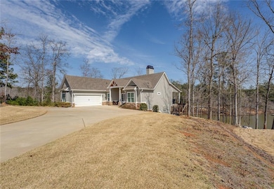 View of front of property with a garage, driveway, and a chimney