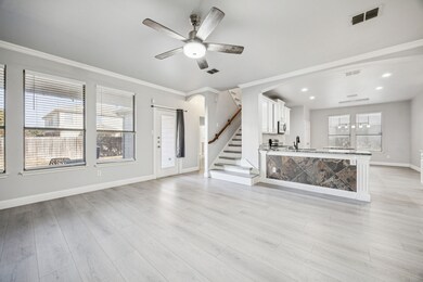 Unfurnished living room with stairway, ornamental molding, light wood finished floors, and ceiling fan