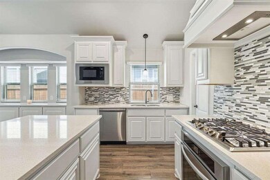 Kitchen featuring white cabinetry, stainless steel