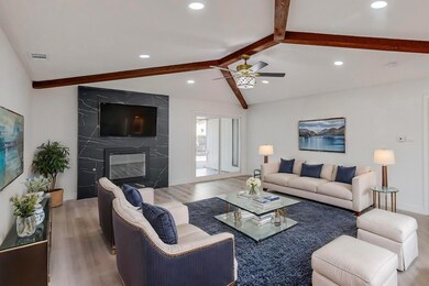 Living room with vaulted ceiling with beams, a lar