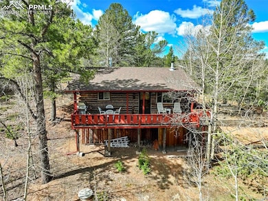 Back of property with log exterior, a wooden deck,