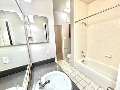 Bathroom featuring vanity, tile patterned floors, and shower / washtub combination