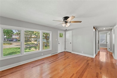 Foyer featuring a barn door, light wood-style floors, a ceiling fan, and a textured ceiling