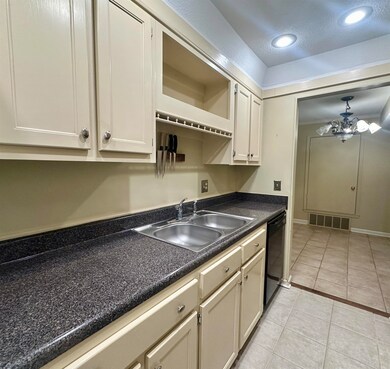 Kitchen featuring new black dishwasher, light tile