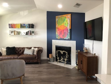Living room with visible vents, a tile fireplace,