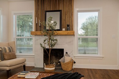 The cozy wood-burning fireplace is complete with an elegant tile surround complimented by a wood mantel with vertical detailing ascending towards the ceiling.
