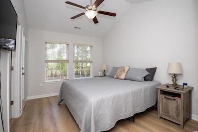 Bedroom featuring baseboards, visible vents, vault