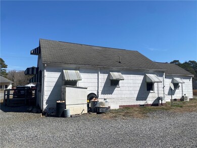View of side of property featuring roof with shing