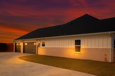 Property exterior at dusk with brick siding, concrete driveway, roof with shingles, and board and batten siding(rendering of sky)