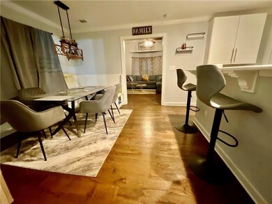 Dining room with baseboards, ornamental molding, and wood finished floors