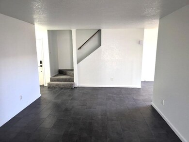 Unfurnished room with stairs, baseboards, and a t