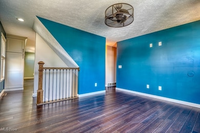 Unfurnished room featuring wood finished floors, a textured ceiling, and recessed lighting