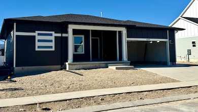 View of front of property with board and batten siding, roof with shingles, driveway, and an attached garage