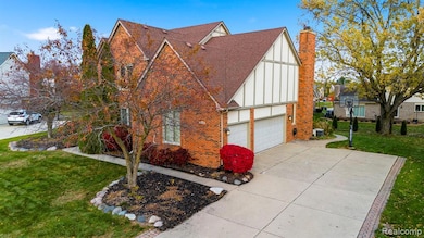 View of side of home with a lawn, a shingled roof, brick siding, and board and batten siding