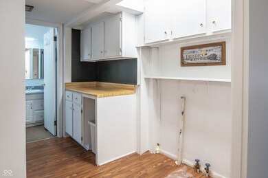 kitchen featuring white cabinetry, light countertops, light wood-type flooring, and a sink