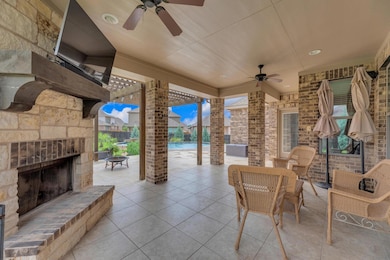 View of patio with an outdoor stone fireplace, an