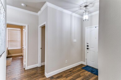Foyer with ornamental molding and dark hardwood / 