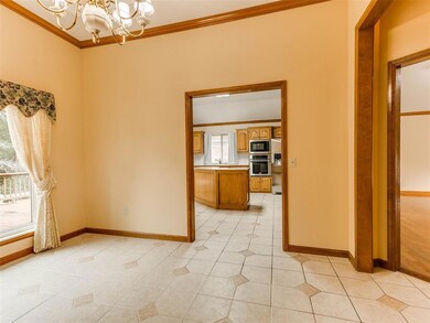 Tiled empty room featuring a chandelier and crown molding